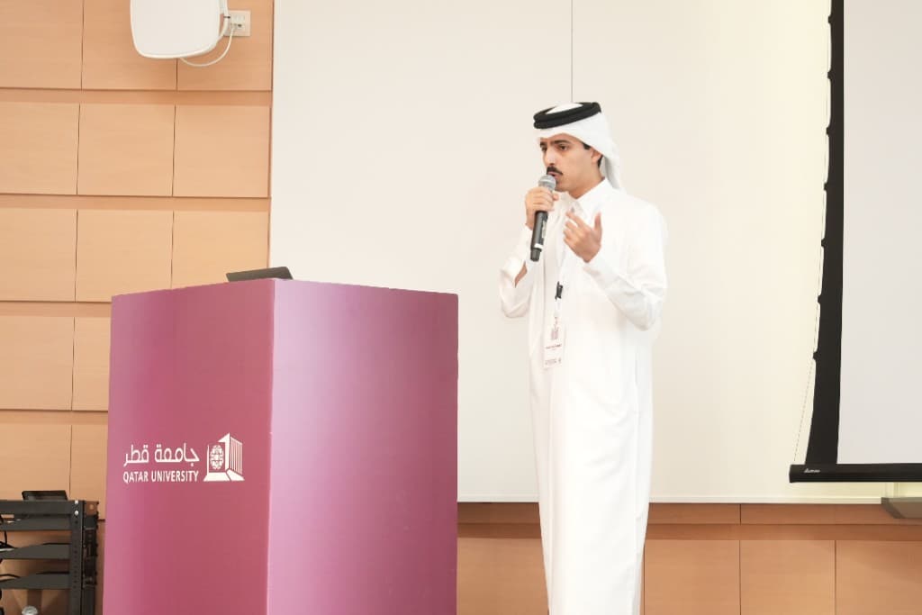 ATF representative presenting at Qatar University with the institutional podium and screen